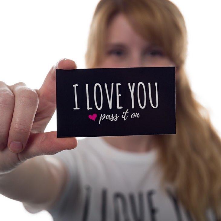 Someone holding an I Love You Pass It On card
